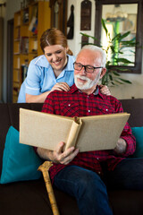 Senior man with young nurse at home getting home care	