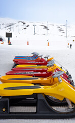 Sleds lined up against the backdrop of a ski slope. Winter holidays. Extreme sport. Vacation, travel content. 