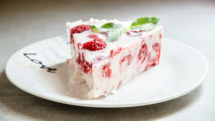 A piece of appetizing raspberry pie on a white plate with love.