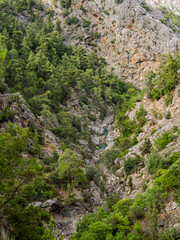 Tourists walk along river in Goynuk Canyon. Aerial view on mountain slopes in Beydaglari Coastal National Park. Turkey.