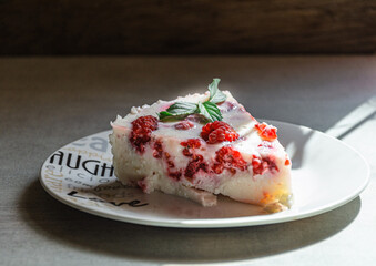 A piece of appetizing raspberry pie on a white plate with love.