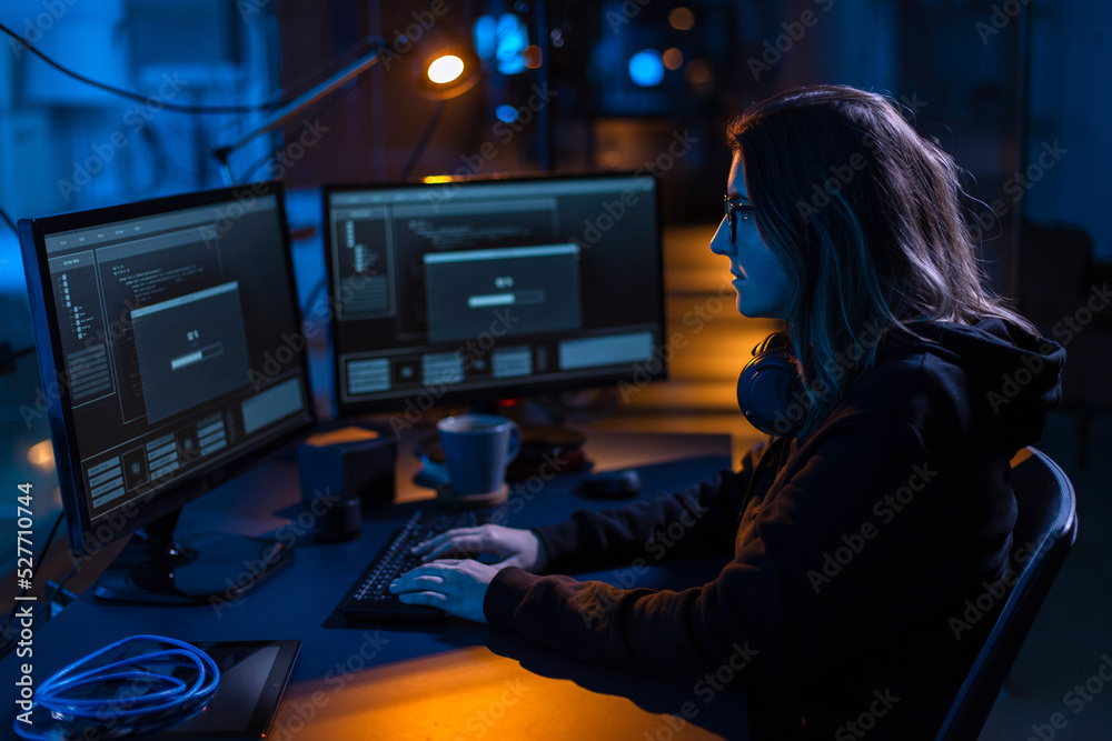 Poster cybercrime, hacking and technology concept - female hacker in dark room writing code or using comput