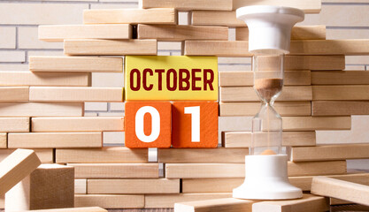 october 1. 1th day of month, calendar date.White vase with dead wood next to cork board with...