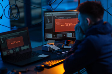cybercrime, hacking and technology concept - male hacker in dark room using computer virus program for cyber attack © Syda Productions