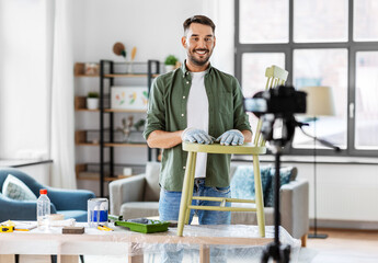 blogging, furniture restoration and home improvement concept - happy smiling man or blogger with...