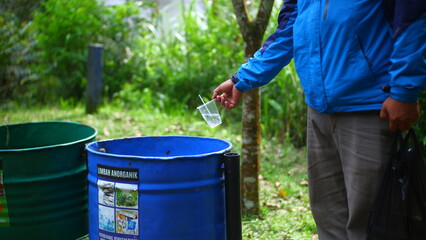 A man who is was wasting garbage in the trash can