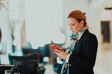 Photo of an elderly woman using a smartphone to carry out business projects and tasks in a modern corporation