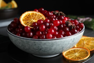 Fresh ripe cranberries, spices and orange slices on grey table, closeup