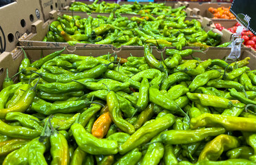 Organic shishito peppers for sale at a supermarket greengrocers section
