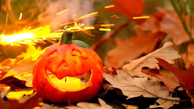 Halloween season. Burning Jack lantern.Pumpkin, brown leaves on stump. High quality 4k footage