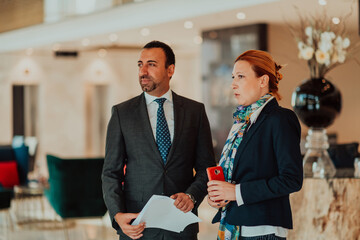 Photo of a businessman and businesswoman discussing business projects in a modern corporation. Selective focus 
