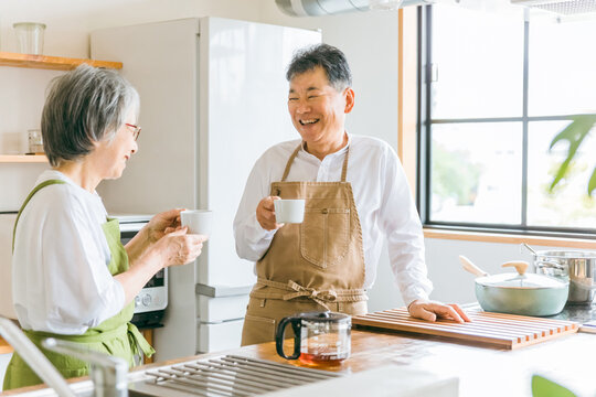 キッチンで話す日本人高齢者夫婦（笑顔）
