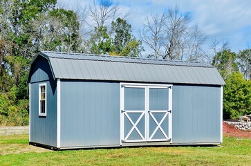 American style wooded shed. A shed is typically simple, single-story roofed structure in a back garden or on an allotment that is used for storage, hobbies, or as a workshop. Exterior view