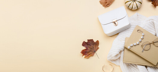 Notebooks, female accessories, sweater and autumn decor on light background with space for text