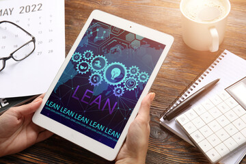 Woman with tablet computer in office. 6 sigma concept