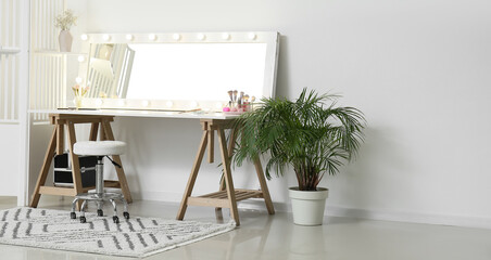 Modern workplace of makeup artist with big mirror in light room