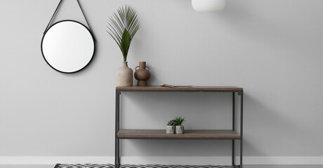 Modern shelf unit near grey wall with mirror