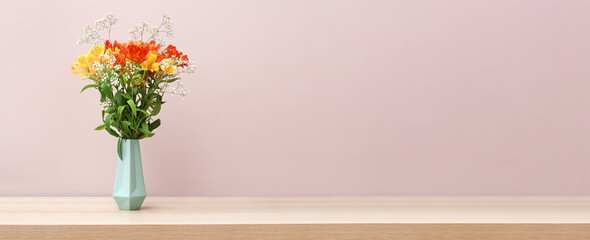 Vase with bouquet of beautiful alstroemeria flowers on table against color background with space for text