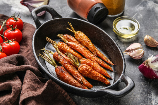 Baking dish with baked carrots on grunge background