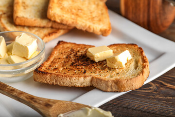 Plate with slice of toasted bread and butter, closeup
