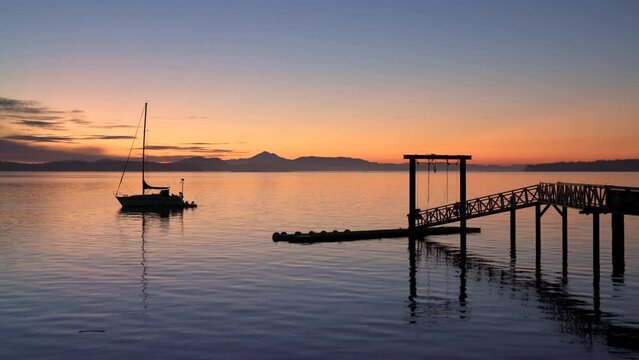 Sidney BC Sailboat and Pier Twilight Dawn 4K UHD. Summer dawn twilight behind a pier and sailboat in Sidney British Columbia, Canada. 4K, UHD.

