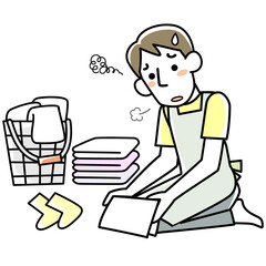 疲れた表情で洗濯物をたたむ若い男性