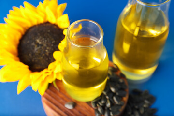 Bottles with sunflower oil on color background, closeup