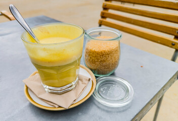 Turmeric Latte coffee on a cafe table,with brown sugar in a bowl,Worcester,UK.