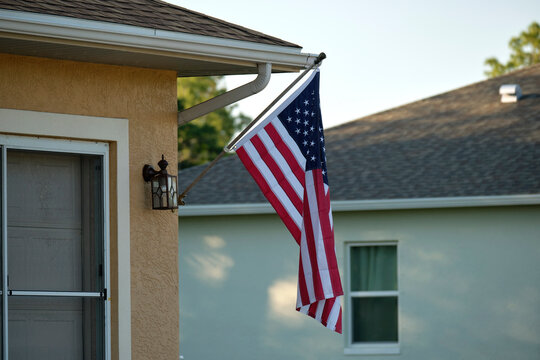 American flag waving on the corner of private residential house, symbol of patriotism