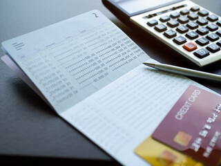 Obraz premium Credit Card on Book Bank with Pen and calculator table background,Technology Electronic Ecommerce Shopping Online,Plan Investment Income for 2023 New Year,Business and Finance concept.