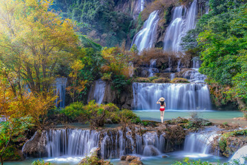 Naklejka premium Tourist woman in swimming suit at Thi Lo Su Waterfall in National Park in Thailand.