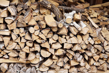 A woodpile of birch firewood stacked on top of each other. Front view.