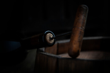 Obraz premium A bottle of wine is opened with a corkscrew. A corkscrew with a wooden handle.Out of focus.Selective focus.