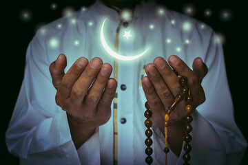 Religious muslim islam man in white session lift two hand for praying to Allah in mosque, isolated on dark background.concept for islamic pray, Ramadan, Eid al Fitr, eid ad-ha, meditation
