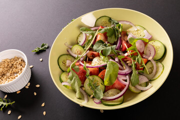 High angle view of healthy salad in bowl on black background, copy space