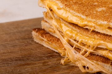 Close-up of fresh cheese sandwich stack on wooden board