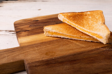 High angle view of fresh cheese sandwich on brown wooden serving board