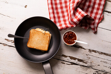 Directly above view of fresh cheese sandwich in cooking pan by dip on white wooden table