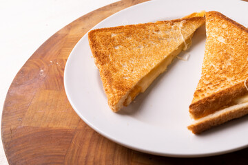 High angle close-up view of fresh cheese sandwich served in plate on wooden table