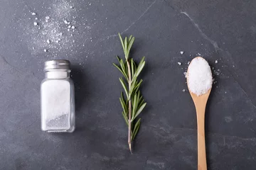 Overhead view of salt shaker with rosemary and wooden spoon arranged side by side on table © wavebreak3