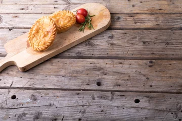 Foto op Canvas High angle view of pies with tomatoes and rosemary on serving board at table with blank space © wavebreak3