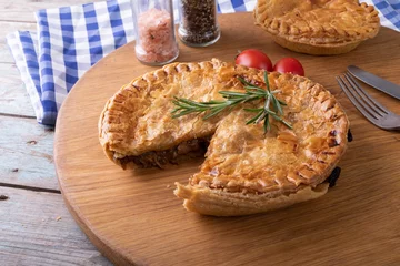 Foto op Plexiglas High angle view of baked stuffed pies with rosemary served on serving board at table © wavebreak3