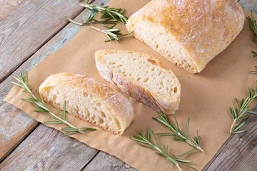 Poster High angle view of bread with rosemary over brown wax paper at table © WavebreakMediaMicro