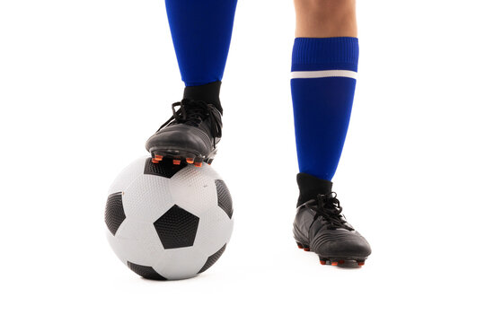 Low section of biracial young female player standing with foot on soccer ball over white background