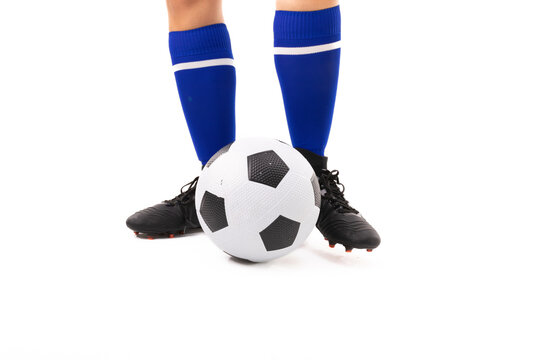 Low section of biracial young female player standing by soccer ball on white background