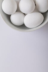 Close-up of white eggs in bowl on table with blank space