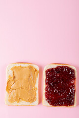 Directly above shot of open face peanut butter and jelly sandwich on pink background with copy space