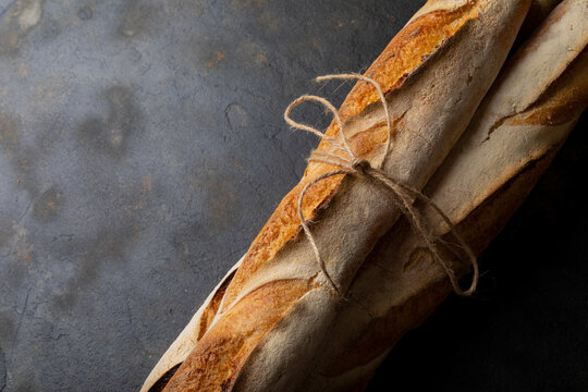 Close-up of baguettes tied up with string on table with empty space