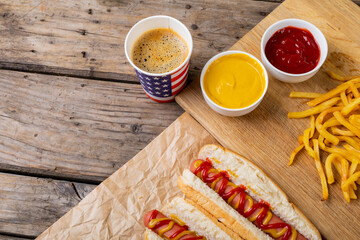Close-up of hot dogs with french fries and sauces by drink on table