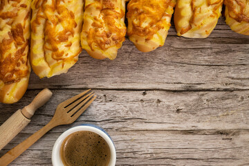 Homemade Cheesy Bread and coffee over wooden background.